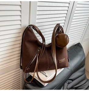 Detail view of retro brown faux suede tote bag with decorative white stitching and small pouch