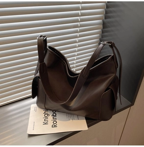 Detail view of dark coffee PU leather tote bag with large capacity and side pockets