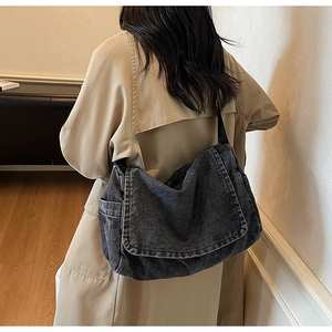Dettaglio della borsa a tracolla in denim grigio scuro con grande capacità e tasca