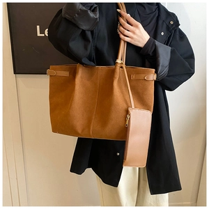 Détail du sac cabas en suédine marron avec pochette zippée assortie sur le mannequin