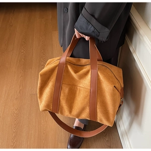 Detail of suede travel bag with brown leather straps and large capacity for short trips