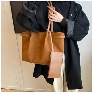 Détail du grand cabas en daim marron avec boucles latérales et pochette à fermeture éclair