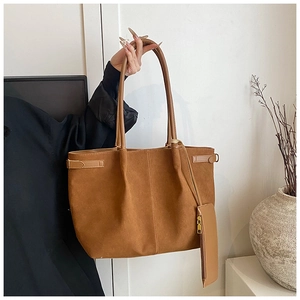 Détail du sac cabas en daim marron avec pochette assortie et boucle latérale élégante