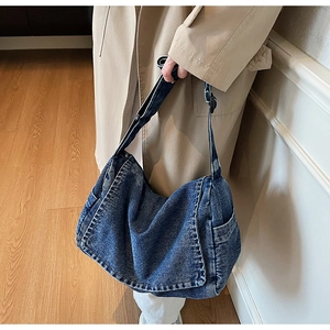 Dettaglio della borsa hobo in denim blu con patta e ampia tracolla regolabile