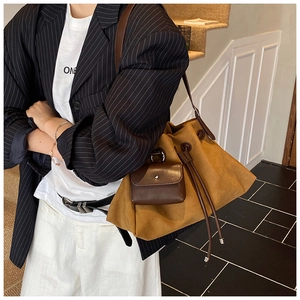 Dettaglio macro della borsa tote in tela kaki con coulisse e mini pochette in pelle