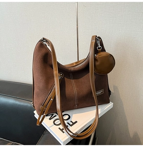 Detail of dark brown suede hobo bag with leather straps and a matching round coin purse