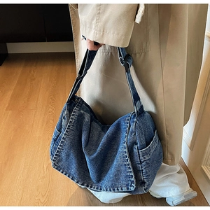 Dettaglio della borsa in denim vintage con grande capacità e tasche laterali sul modello