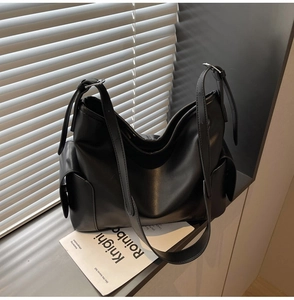 Detail view of black PU leather half-moon shoulder bag with adjustable strap and side pockets