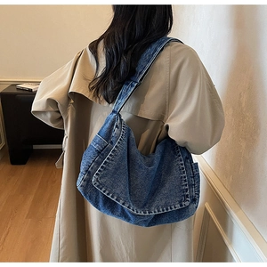 Dettaglio della borsa hobo vintage in denim blu che mostra la trama e le cuciture sulla tracolla