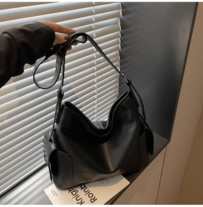 Macro detail of high-quality PU leather texture and side pocket on this black hobo bag