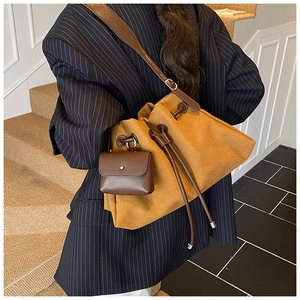 Detail of canvas bucket bag with leather drawstring and matching mini pouch accessory