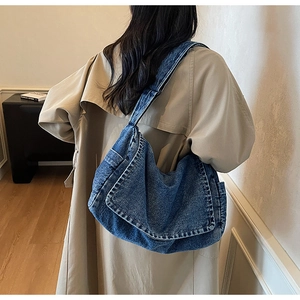 Vista dettagliata della borsa a spalla in denim con trama lavata e patta a scatto