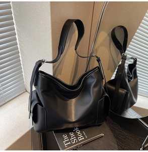 Detail of black PU leather hobo bag with side pockets and adjustable wide shoulder strap