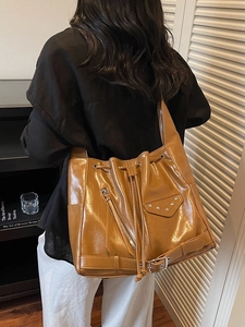 Caramel vintage leather bucket bag with metallic rivets and motorcycle style accents