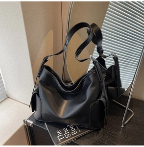 Close-up of matte black PU leather Hobo bag with wide strap and silver metal buckle details