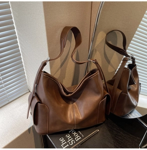 Close-up of a vintage dark brown PU leather tote bag with elegant silver buckle detail