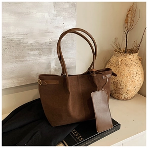 Détail d'un cabas en daim marron foncé avec petite pochette assortie et boucle métal