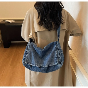 Vista dettagliata di una borsa a tracolla in denim lavato retrò indossata da una modella