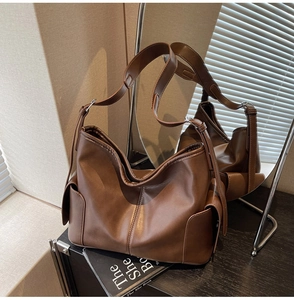 Detail view of large brown vintage PU leather hobo bag with wide strap and side pockets