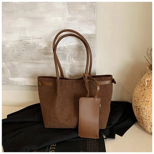 Sac cabas en daim marron foncé avec pochette zippée assortie sur fond minimaliste