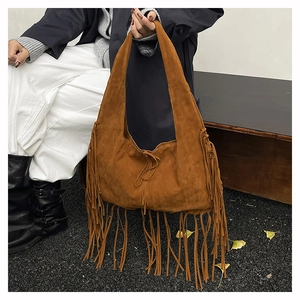 Detail of a brown suede hobo bag with long fringes and boho-style tie closure