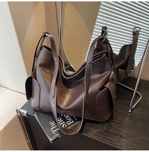 Detail of soft dark brown PU leather tote bag with wide strap in vintage setting