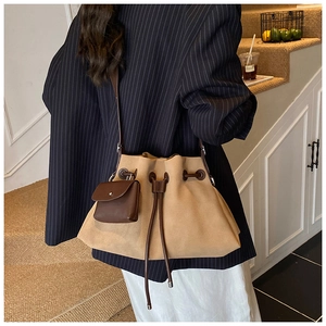 Detail of a large khaki suede tote bag with drawstring closure and small hanging pouch