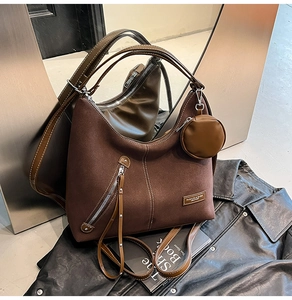 Detail of vintage brown suede tote bag with shiny leather straps and mini coin purse