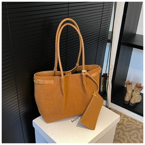 Détail d'un grand cabas en daim marron avec boucle en métal et pochette assortie