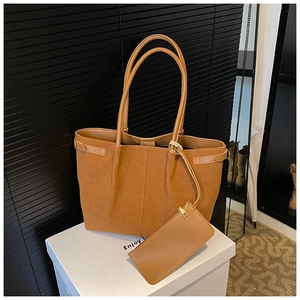 Détail du sac cabas en daim caramel avec pochette assortie sur marches blanches