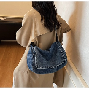 Vista dettagliata della borsa a tracolla grande in denim vintage con un trench color kaki
