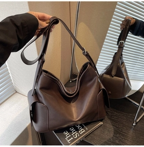 Detail of dark brown matte PU leather tote with side pockets and adjustable wide strap