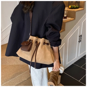 Detailed view of khaki suede bucket bag with drawstring closure and dark brown pouch