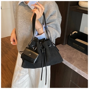 Detail view of a black drawstring bucket bag with a matching small pouch on strap