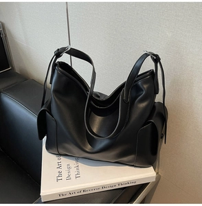 Close-up of black PU leather tote bag featuring side pockets and dual handles