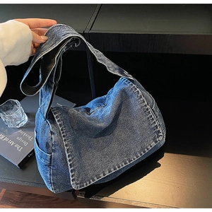 Dettaglio della borsa a tracolla in denim blu con texture e ampia tracolla regolabile