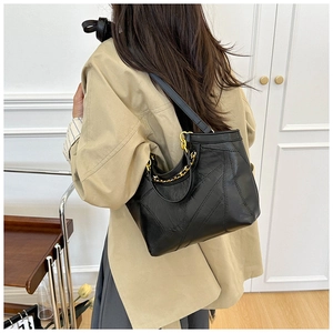 Nahaufnahme schwarzer Shopper mit Ziernähten und goldener Kette am Schultergurt für Damen