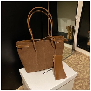Détail du sac cabas en daim marron avec pochette assortie sur un présentoir