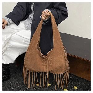 Detail shot of brown suede hobo bag with long tassels and bohemian hand-stitched seams