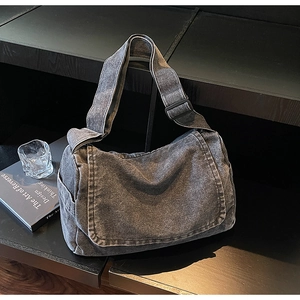Dettaglio della borsa a tracolla in denim grigio scuro con ampia tracolla regolabile