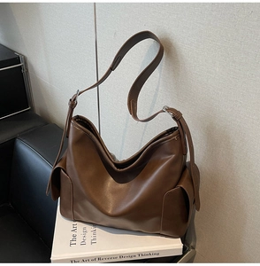 Detailed macro view of deep brown matte PU leather shoulder bag with side pocket and strap