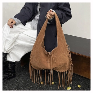 Detailed close-up of a brown suede tote bag with long tassels and drawstring closure