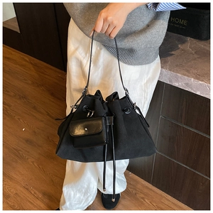 Detail of black drawstring bucket bag with matching mini pouch and leather strap