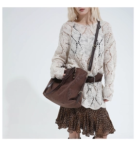 Detail of leopard print tote bag with brown leather straps shown on a model