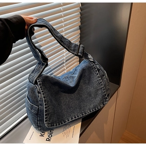Dettaglio della borsa a tracolla in denim vintage con cinturino regolabile e patta