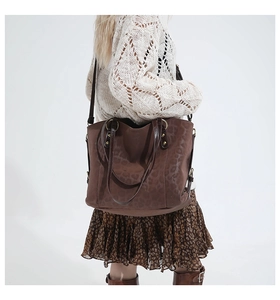 Detail of leopard print suede texture and gold rivets on a large brown tote bag