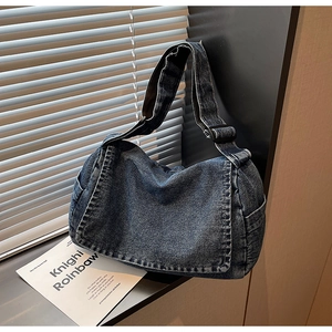 Dettaglio della borsa in denim vintage con trama del tessuto pesante e cuciture bianche