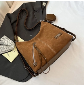 Detail of brown vintage tote bag with suede texture, zipper tassel, and small round coin purse