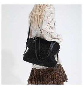 Detail view of large leopard print tote bag being carried by a model for size perspective