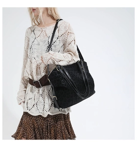 Close-up of black leopard print tote bag featuring gold hardware and adjustable strap